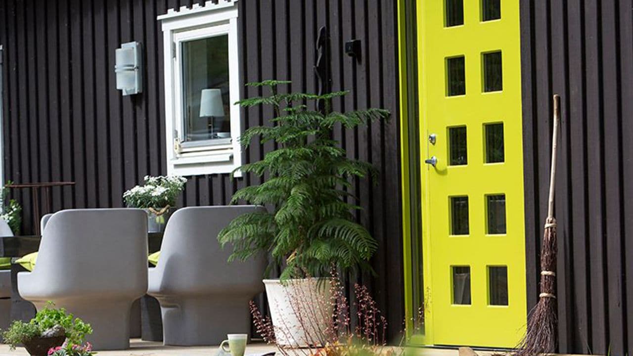Svart hus med limegrønn ytterdør fra Swedoor for ytterdør inspirasjon.