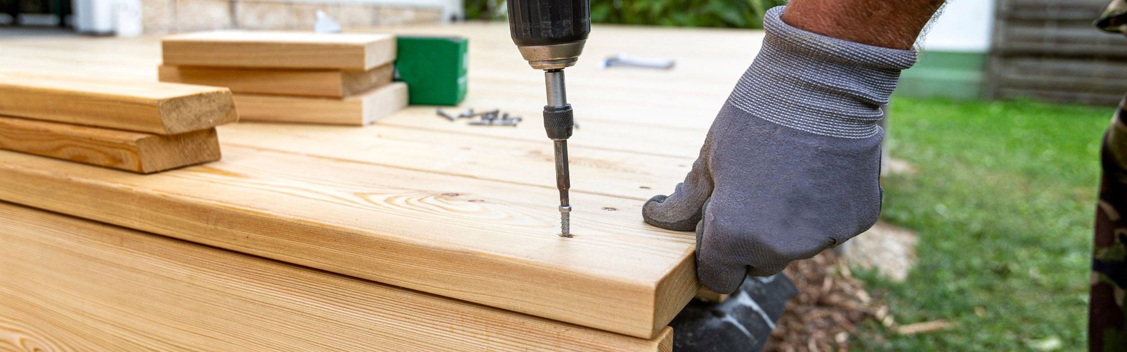 Snekker som bygger terrasse med drill.