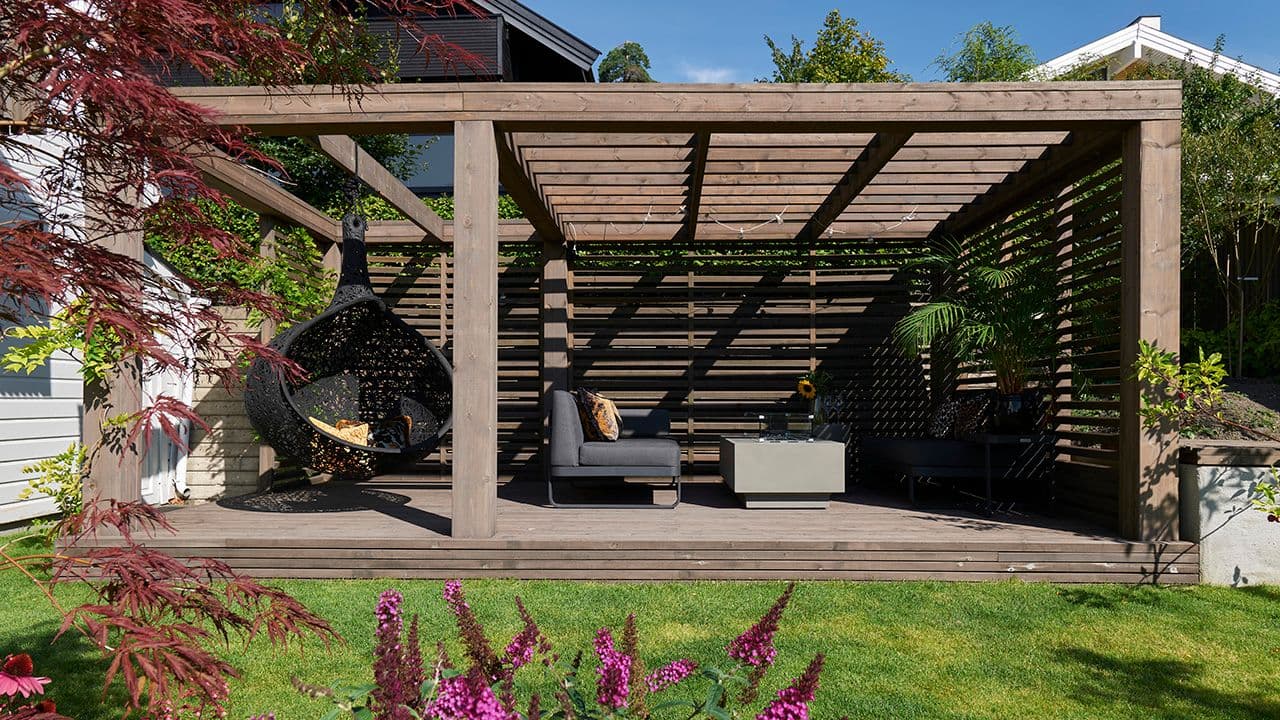 Pergola med spilevegg og tak.