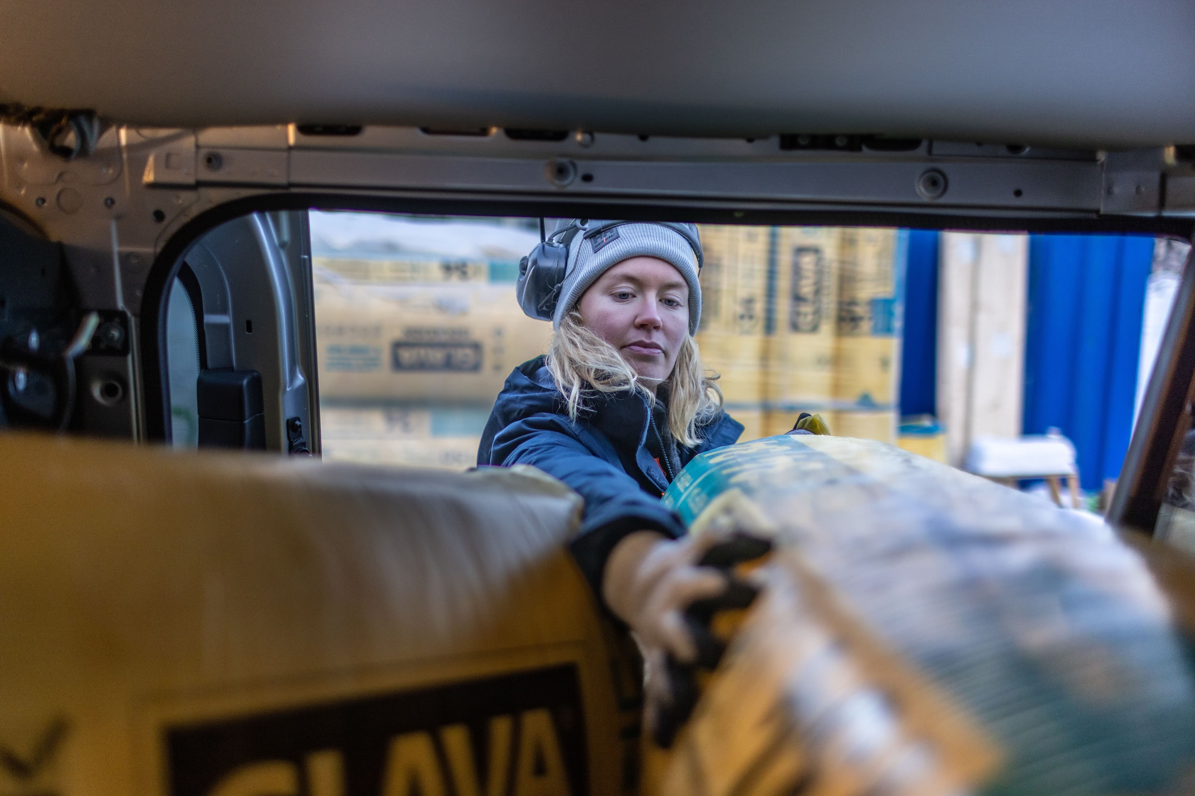 En dame henter glava isolering fra bilen