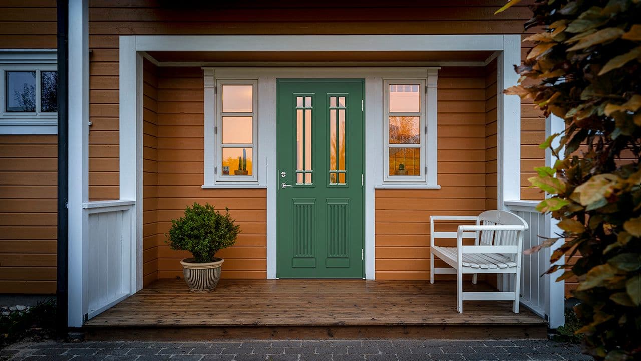 Male ytterdør grønn på gult hus.