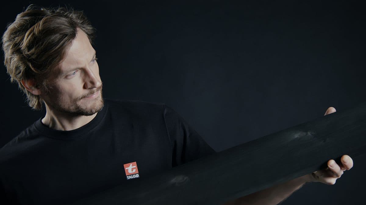 mann fra Talgø holder et kledningsbord fra MøreRoyal i hendene