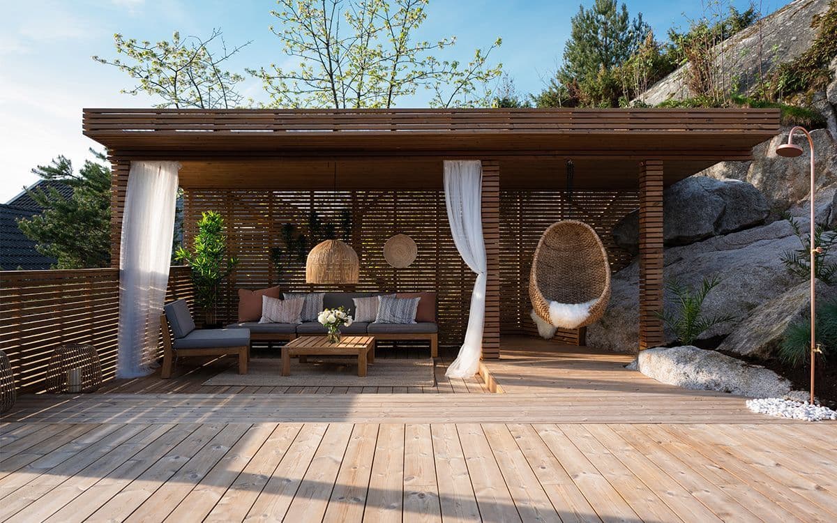 Lyse terrassebord i termofuru fra Moelven med pergola og utedusj.