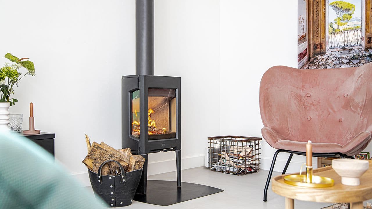 Liten støpejernsovn i moderne design fra Jøtul i hvit stue.