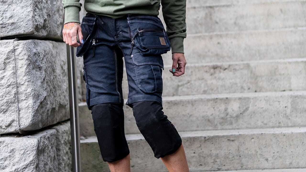 Dame med arbeidsbukse i trapp.