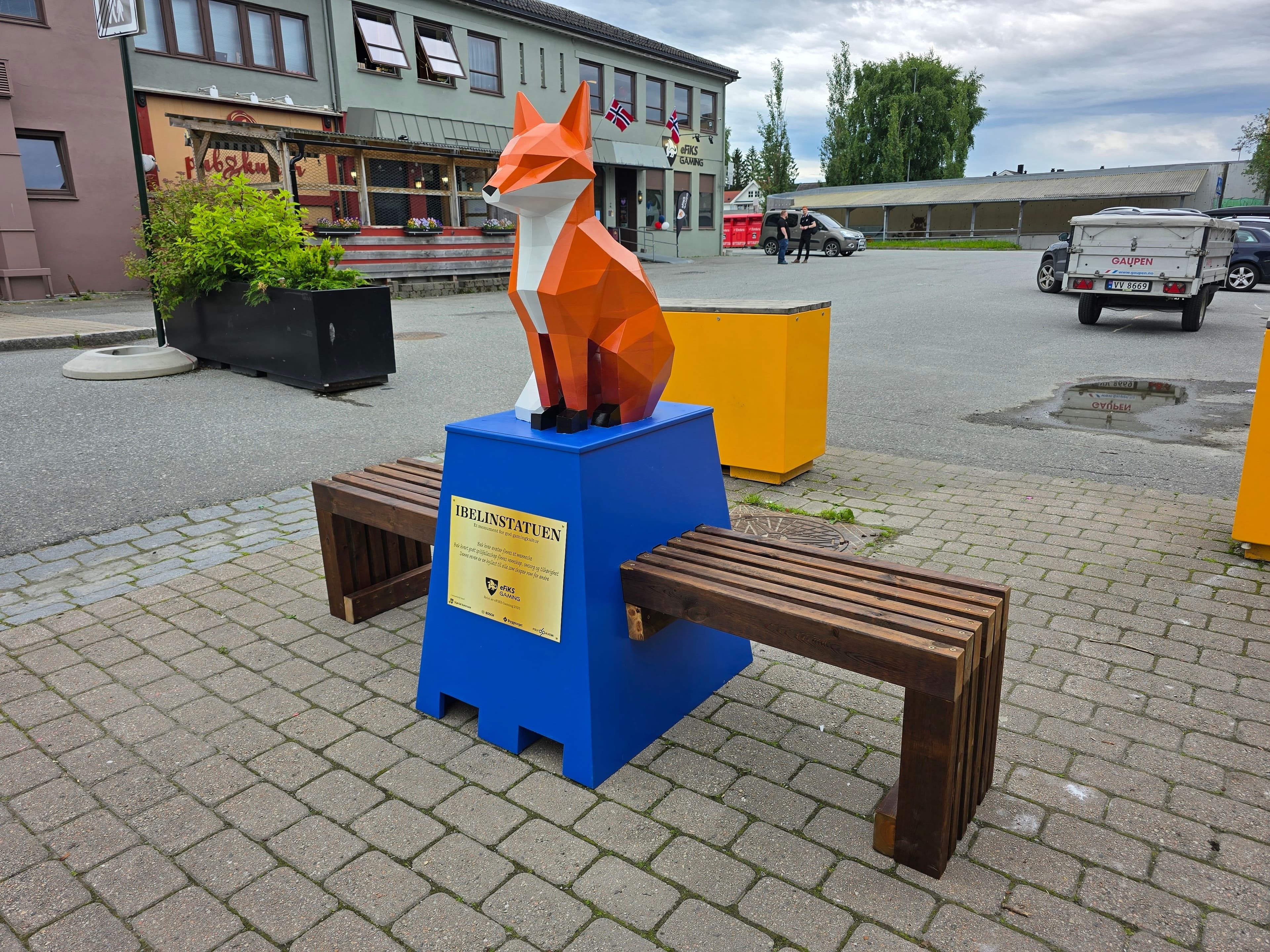 Ibelinstatuen plassert på en snekret blå pidestal av tre.