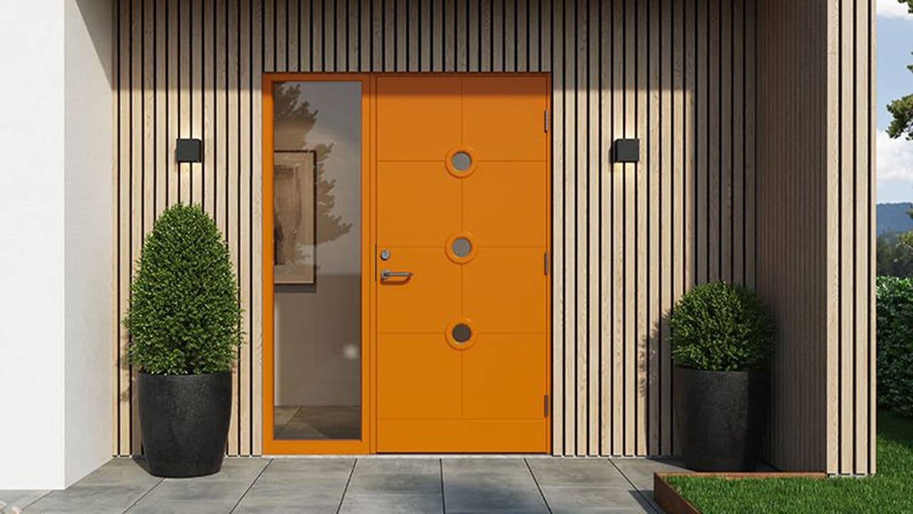 Moderne funkisvilla med oransje ytterdør og sidefelt.