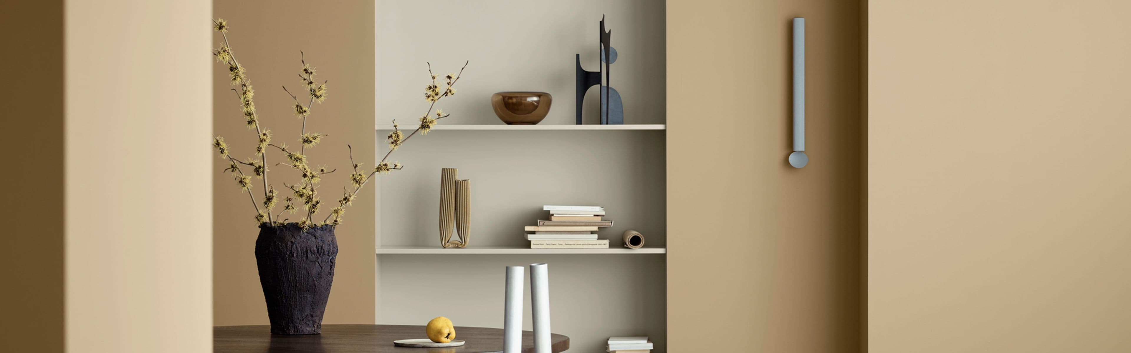 Oppholdsrom med åpen hylle hvor hylleveggen er malt med 12075 Soothing Beige og vegger i fargen 1632 Rock Sugar fra Jotuns nye fargekart CANVAS.